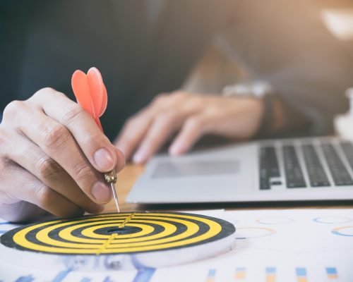 Businessman holding red dart push on target. Business strategy planning success target goals. Business development concept